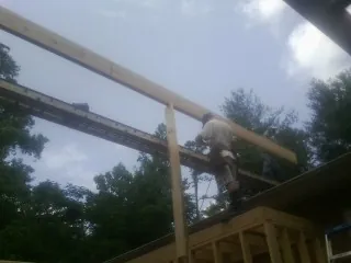 Carpenter setting a ridge beam over a new addition frame — Ice Dam Removal by Roofing Brothers in Valley Cottage