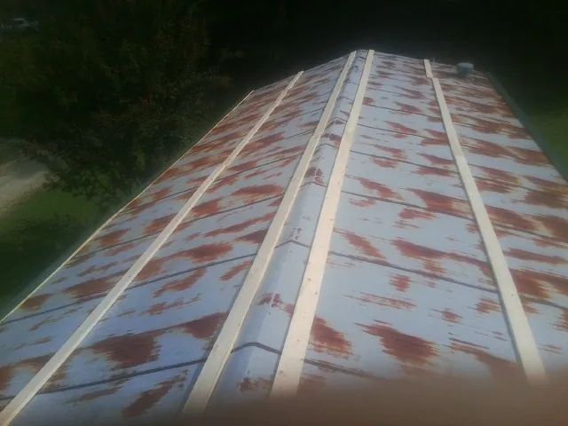 Rusted metal roof panels with new wood purlins before replacement — Storm Damage Roof Repair in Valley Cottage by Roofing Brothers