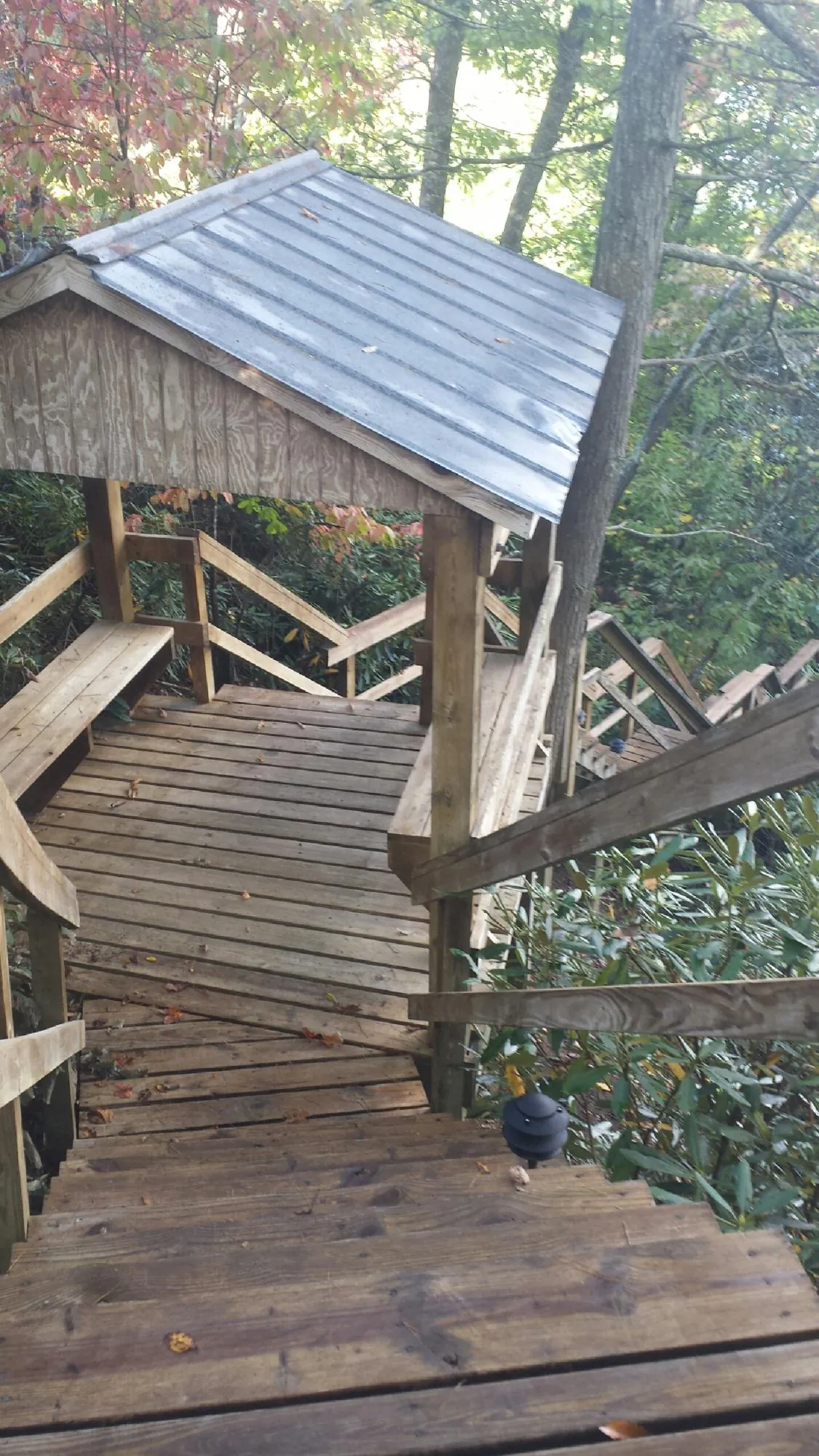 Metal roofed shelter over wooden steps on a wooded walkway — Skylight Repair & Installation work by our crew in Valley Cottage